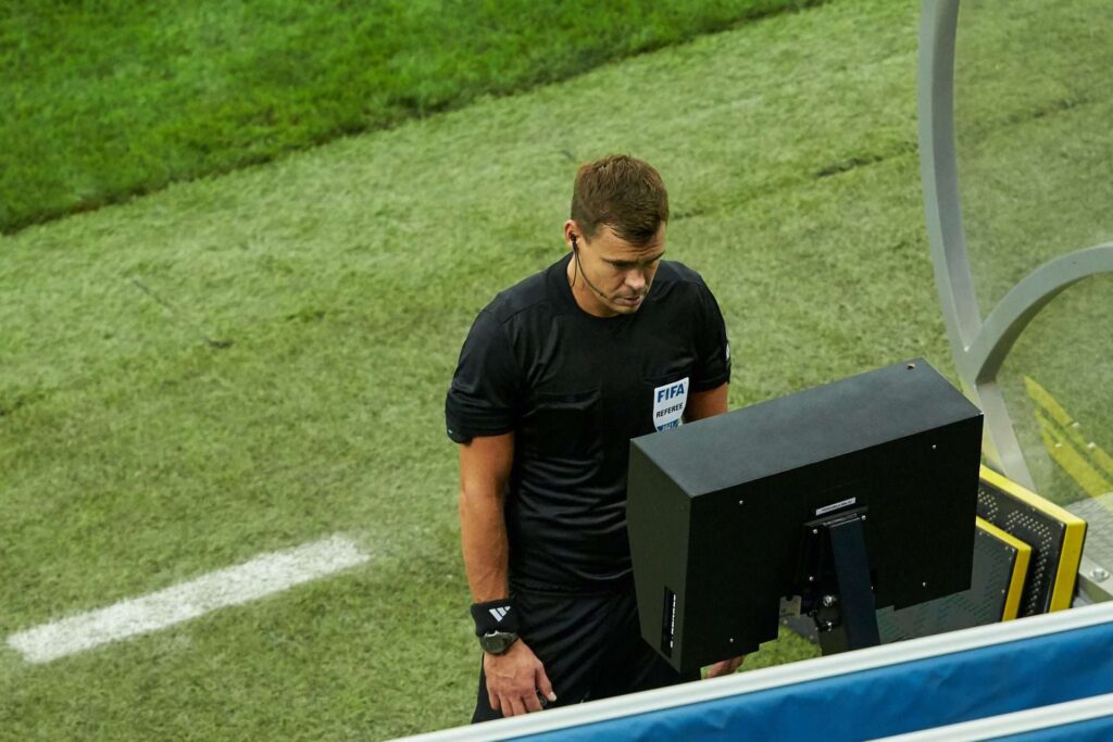 Árbitro de futebol olhando para a tela VAR